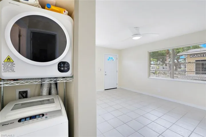 Laundry room featuring washer / clothes dryer, light tile patterned floors, and a ceiling fan
