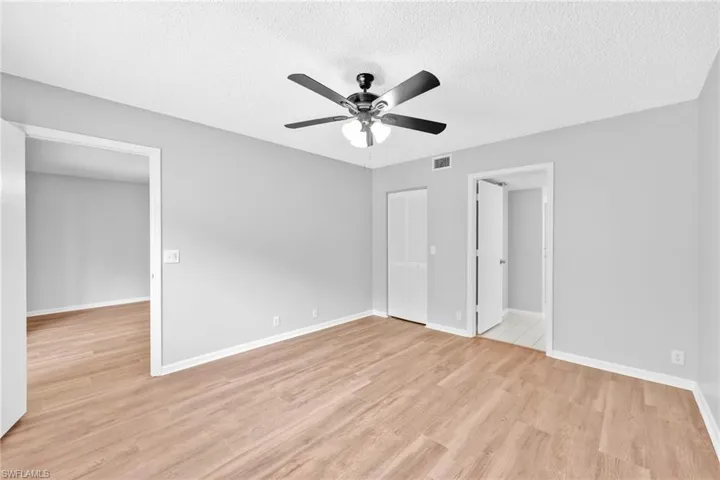 Unfurnished bedroom with a textured ceiling, light wood finished floors, a ceiling fan, and a closet