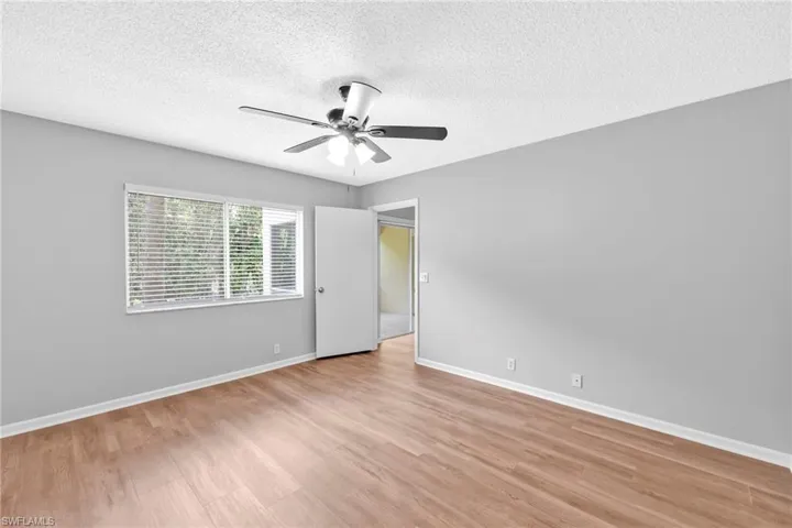 Unfurnished bedroom featuring a textured ceiling, ceiling fan, and light wood finished floors
