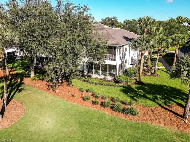 Back of house featuring a sunroom and a lawn
