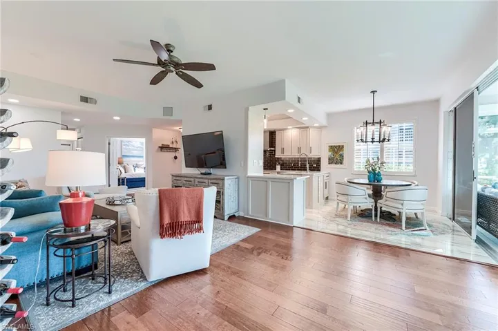 Living room featuring light wood-type flooring, a chandelier, ceiling fan, and recessed lighting