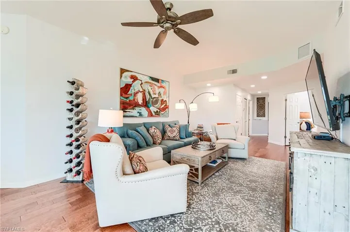 Living area with light wood-type flooring, recessed lighting, and a ceiling fan