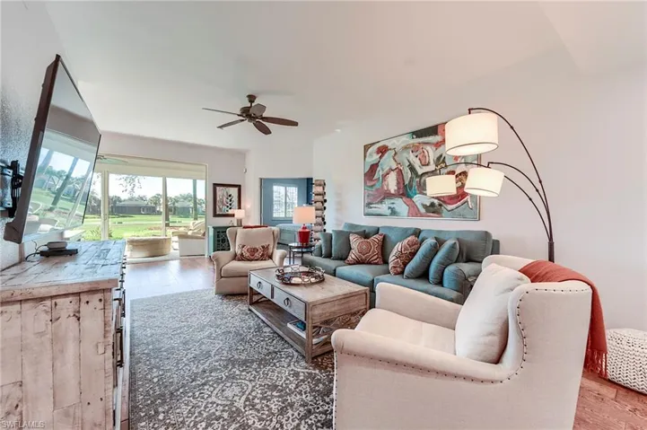 Living area with hardwood / wood-style floors and ceiling fan