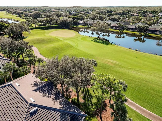Drone / aerial view of a golf course and a nearby body of water