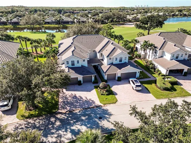Aerial view of residential area featuring a nearby body of water and a local golf course