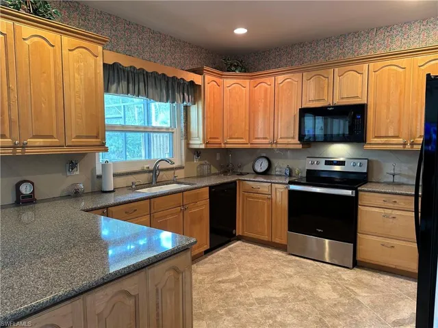 Kitchen with black appliances and sink