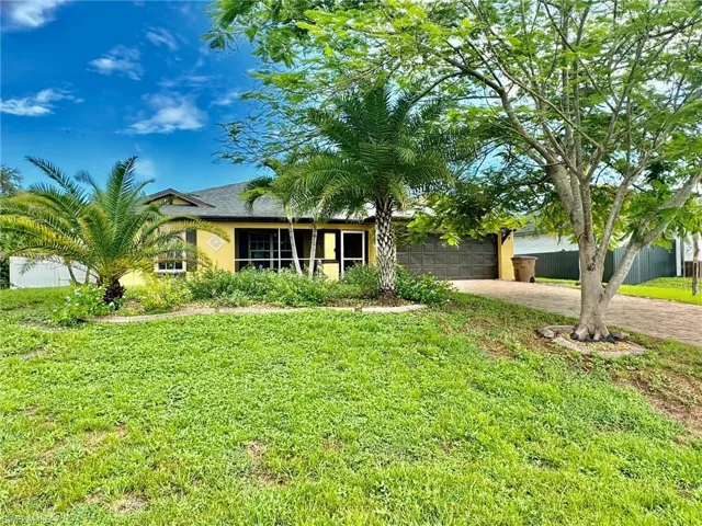View of front facade with a garage and a front lawn