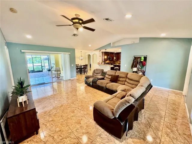 Living room with lofted ceiling and ceiling fan