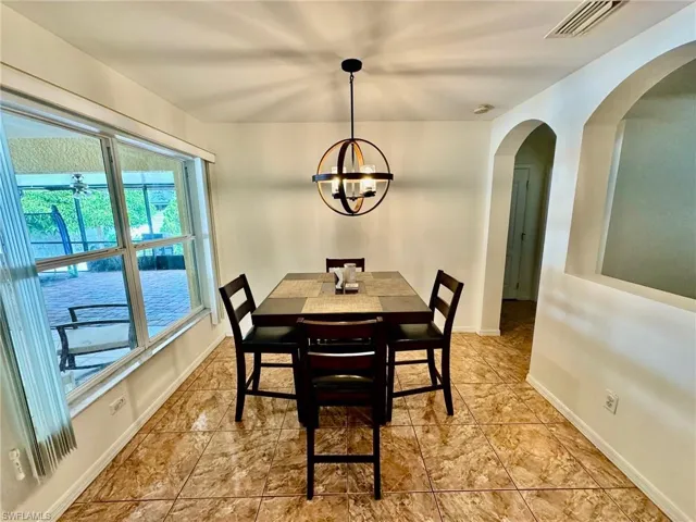 Dining space featuring ceiling fan with notable chandelier