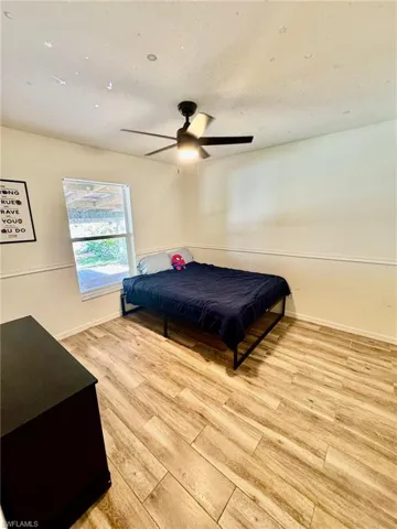 Bedroom with ceiling fan and light wood-type flooring