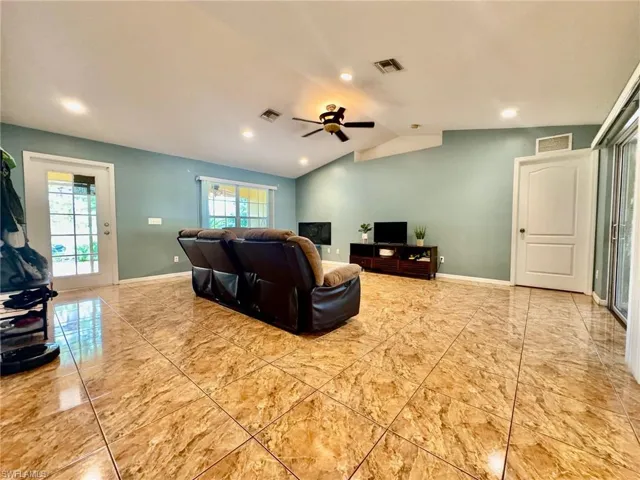 Living room featuring ceiling fan and vaulted ceiling