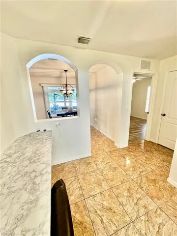 Unfurnished dining area with ceiling fan with notable chandelier