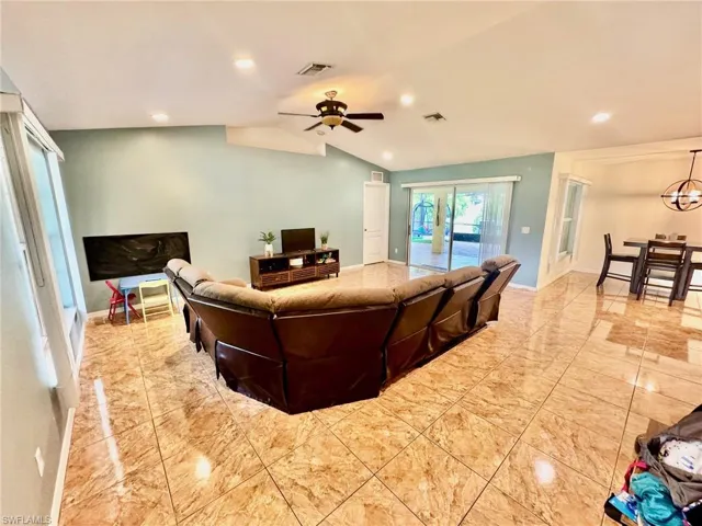 Living room with lofted ceiling and ceiling fan