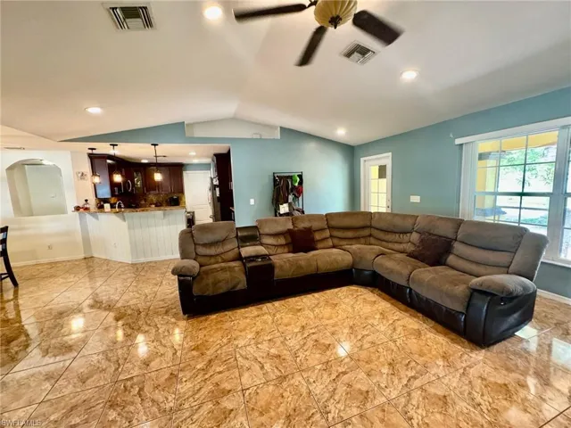 Living room with lofted ceiling and ceiling fan