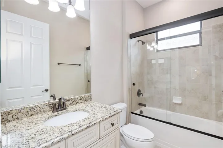 Vanity with light-toned countertop and an undermount sink