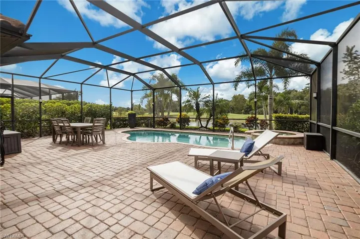 Screened lanai featuring a swimming pool, integrated spa, and paver patio