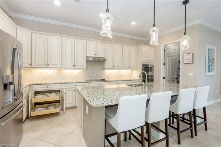Gourmet kitchen featuring a large island with seating, stainless steel appliances, white cabinetry, and recessed lighting
