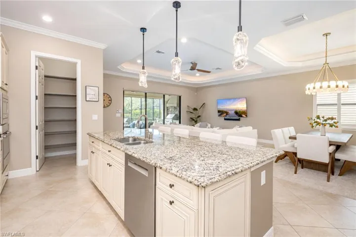 Kitchen island featuring a double basin sink and stainless steel dishwasher