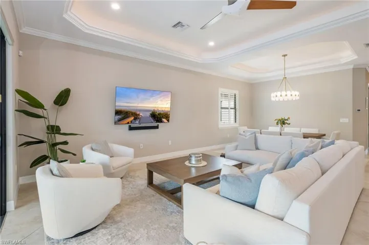 Tray ceiling with crown molding, recessed lighting, and tile flooring