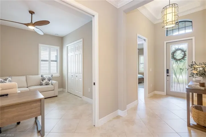 Foyer with tile flooring and a decorative entry door featuring an arched transom window