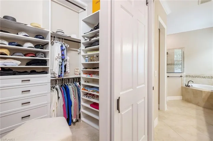 Primary bedroom custom built-in closet system with shelving and hanging rods