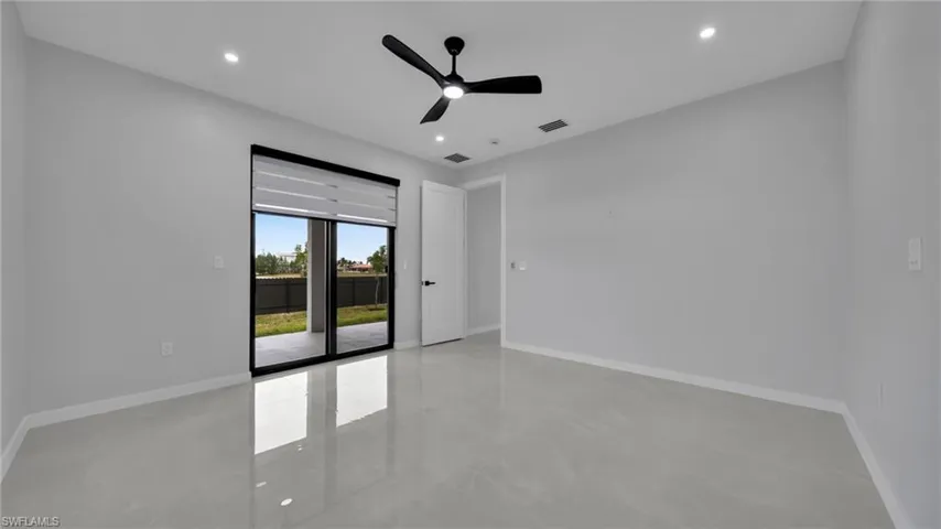 Empty room featuring finished concrete flooring, ceiling fan, and recessed lighting