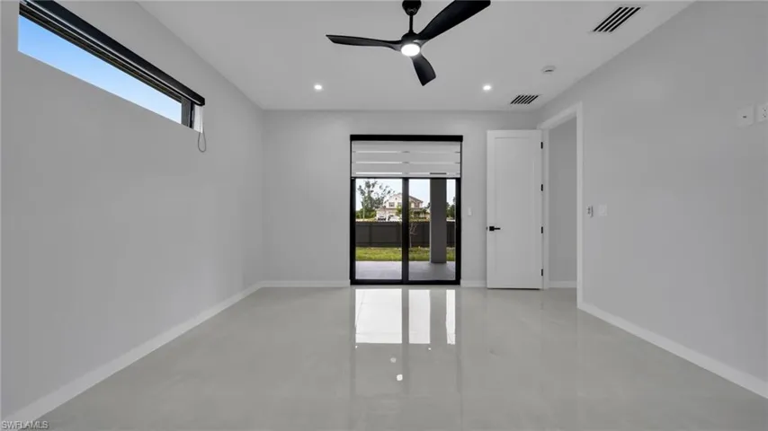 Spare room featuring healthy amount of natural light, finished concrete flooring, a ceiling fan, and recessed lighting