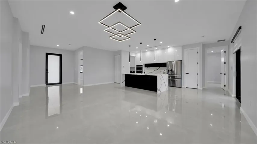Unfurnished living room with recessed lighting and baseboards