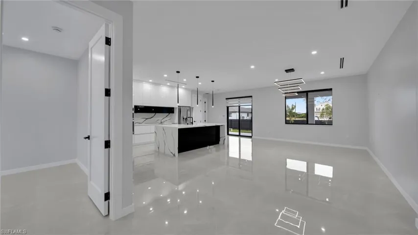 Kitchen with a kitchen island with sink, decorative light fixtures, white cabinets, recessed lighting, and modern cabinets