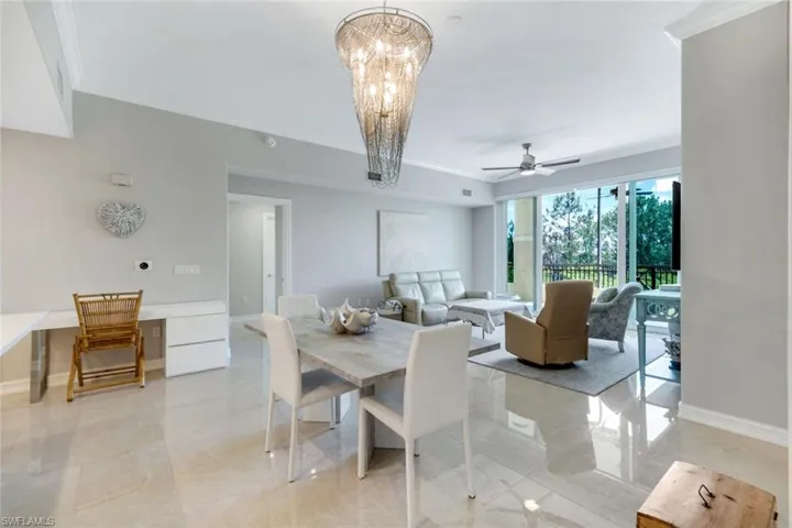 Dining area with crown molding, baseboards, a ceiling fan, and a chandelier