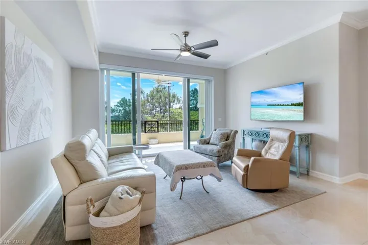 Living area with crown molding, a ceiling fan, and baseboards