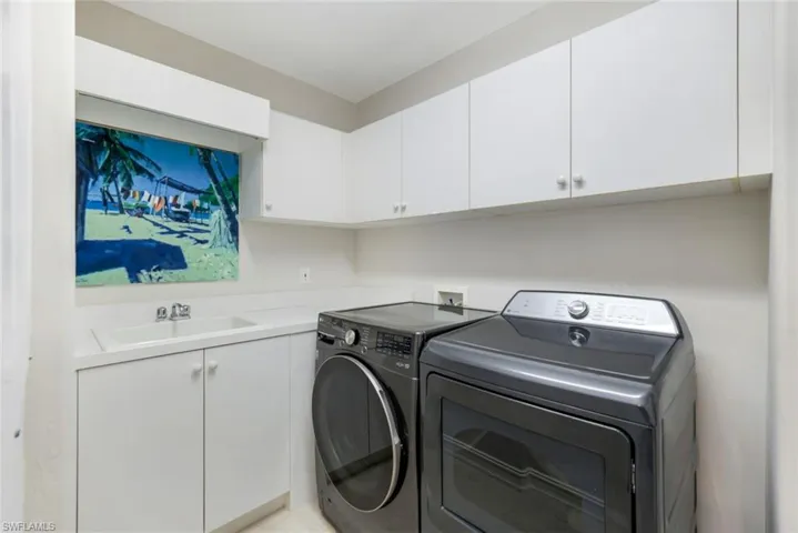 Laundry area featuring washer and clothes dryer and cabinet space