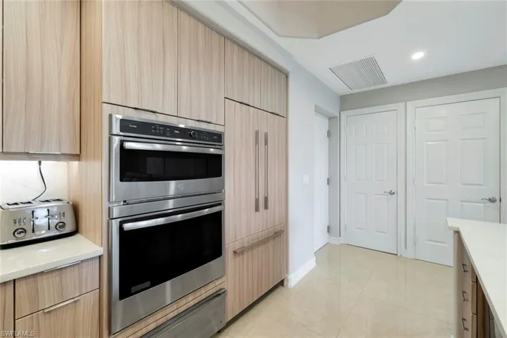 Kitchen featuring double oven, light brown cabinets, light countertops, modern cabinets, and recessed lighting