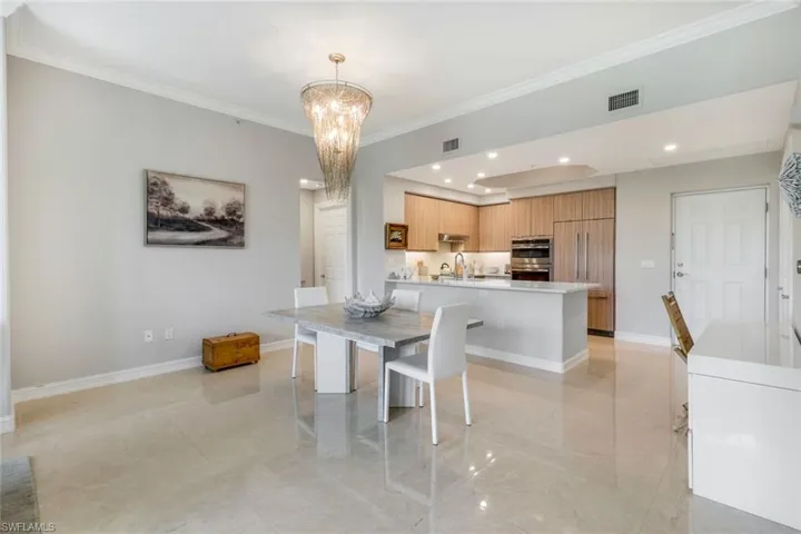 Dining area and Breakfast bar, a chandelier, baseboards, recessed lighting and light tile patterned floors