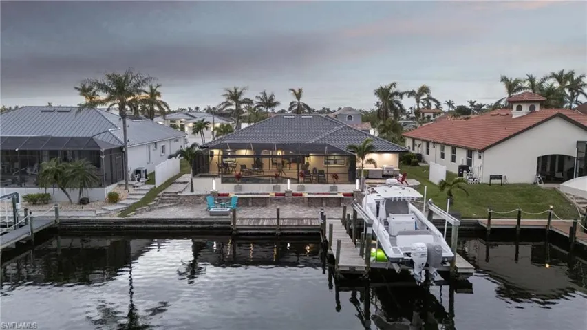 Dock area featuring a lanai, a water view, and a pool