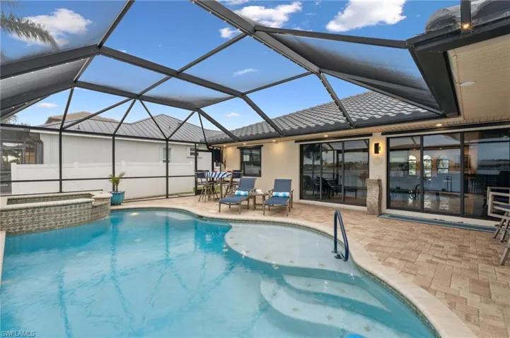 View of pool featuring a patio area, a lanai, and an in ground hot tub