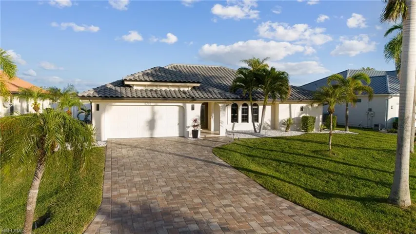 Mediterranean / spanish home with a garage and a front lawn