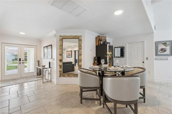 Dining space with french doors and ornamental molding