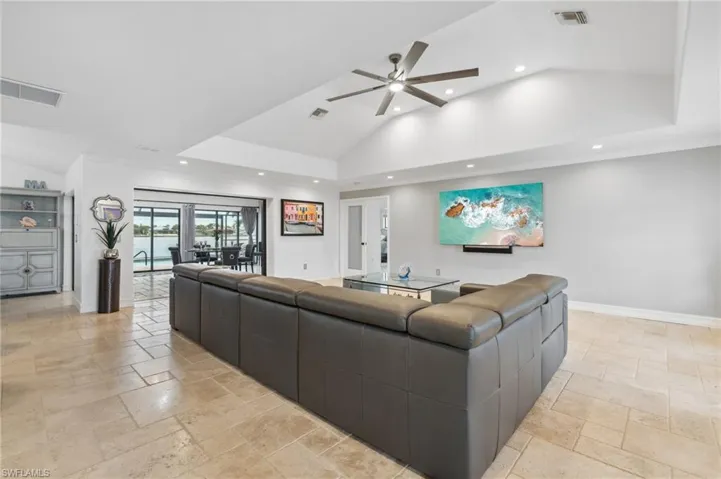 Living room featuring ceiling fan and lofted ceiling