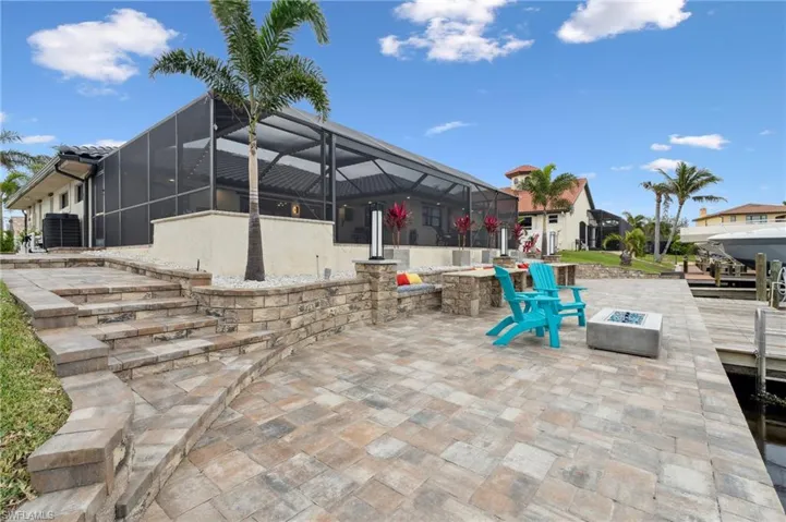 View of patio / terrace with a fire pit, glass enclosure, and cooling unit