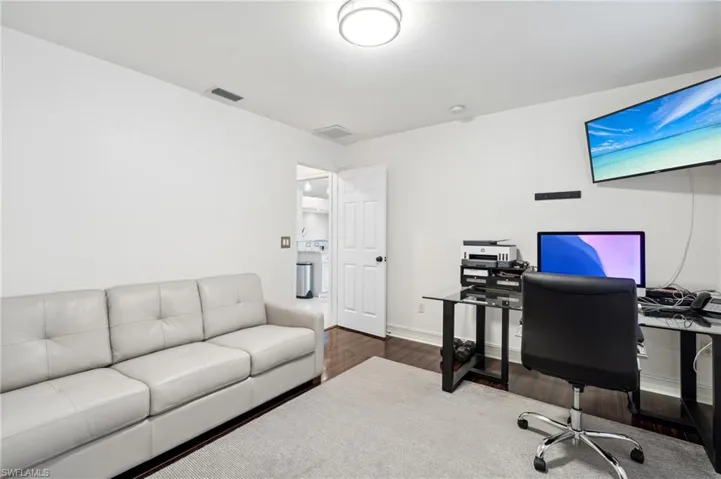 Office area with washer / clothes dryer and dark hardwood / wood-style flooring