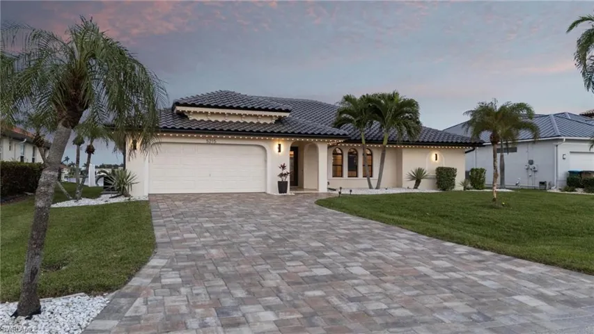 Mediterranean / spanish-style house with a lawn and a garage
