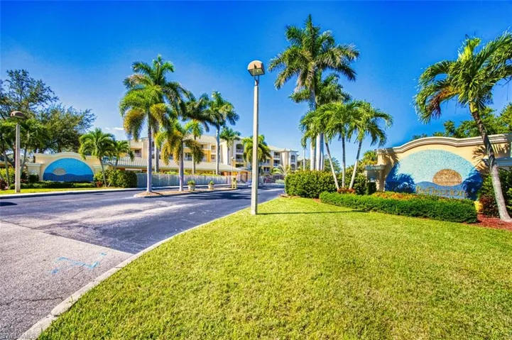 View of asphalt street featuring street lights and curbs