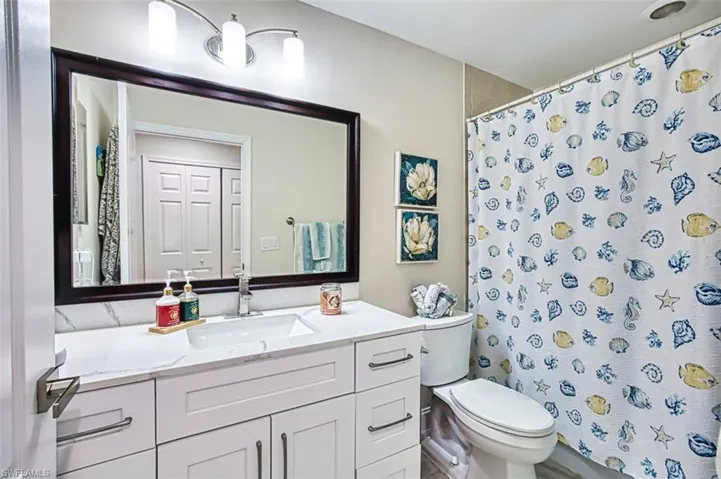 Bathroom with a shower with shower curtain and vanity