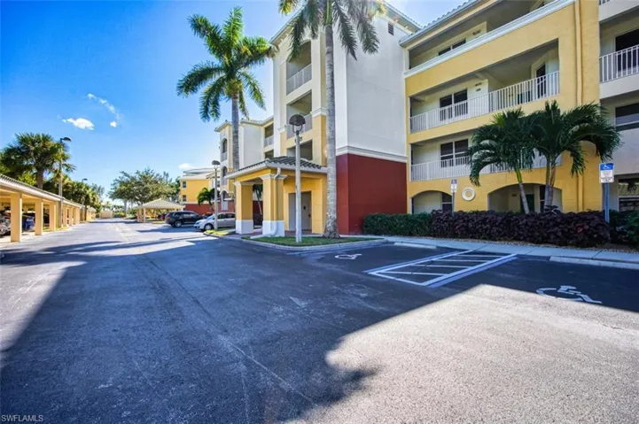 View of building exterior featuring uncovered parking