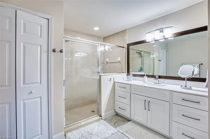 Full bath with vanity, a shower stall, a closet, and recessed lighting