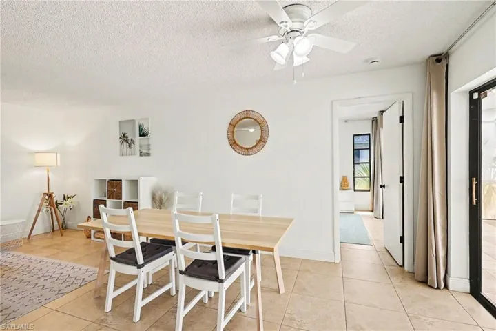Open-concept dining area featuring tile flooring and a ceiling fan with integrated lighting