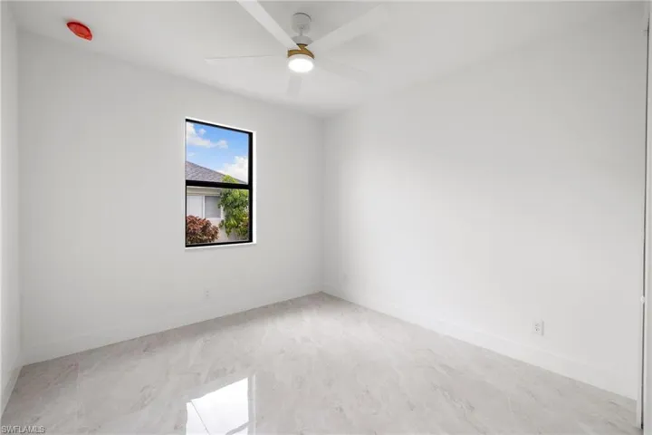 Spare room featuring ceiling fan and baseboards