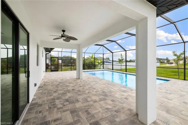 Swimming pool featuring ceiling fan, a lanai, and a patio