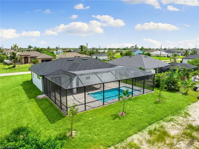 Outdoor pool featuring a residential view, a patio area, a lawn, and a lanai